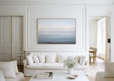Modern living room with white sofa, decorative pillows, and a large framed wall artwork of Adrift.